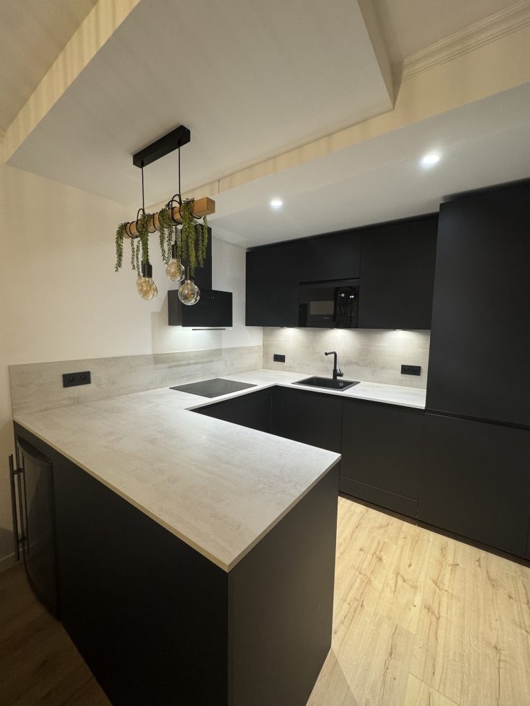 Cuisine américaine moderne, design et entièrement équipée dans un appartement 3 pièces rénové entièrement, dont l'agencement a été repensé avec inversion de la cuisine et de la salle de bains pour plus de confort et de praticité.